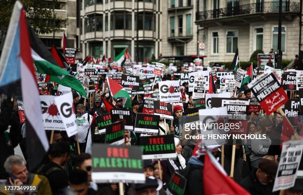 People gather with placards to take part in a 'March For Palestine' in London on October 21 to "demand an end to the war on Gaza". The UK has pledged...