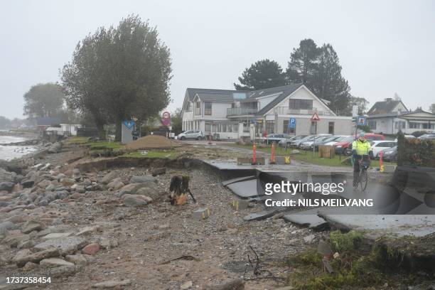 Man cycles on a damaged street in Stroeby Egede on Zealand, Denmark, on October 21 after the area was affected by a heavy storm. / Denmark OUT