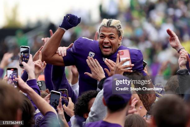 Rome Odunze of the Washington Huskies celebrates as fans storm the field after the Washington Huskies beat the Oregon Ducks 36-33 at Husky Stadium on...