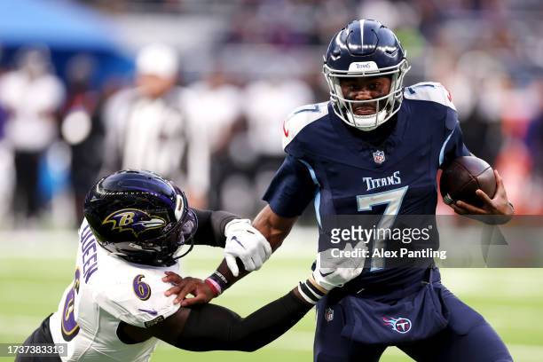 Malik Willis of the Tennessee Titans stiff arms Patrick Queen of the Baltimore Ravens in the fourth quarter during the 2023 NFL London Games match...