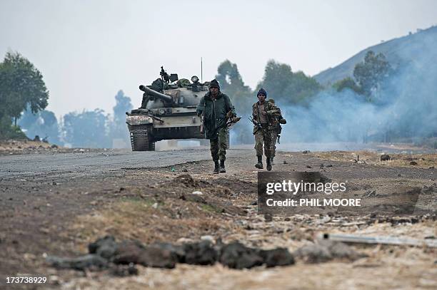 Congolese army soldiers walk ahead of a tank through Kanyarucinya, around 10km from Goma, in the east of the Democratic Republic of the Congo on July...