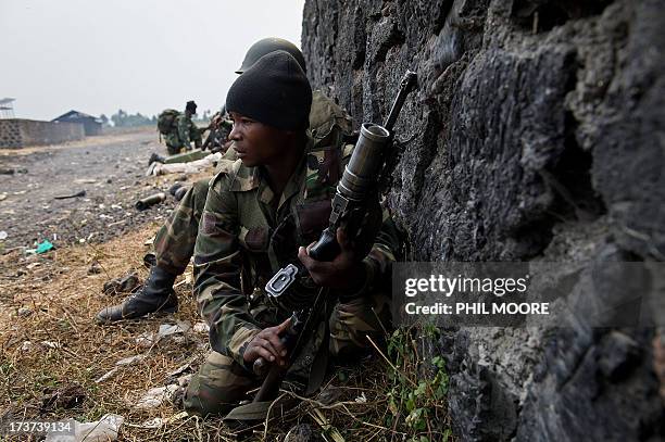 Congolese army soldiers take cover as incoming bullets and shells hit near to their position in Kanyarucinya, around 10km from Goma, in the east of...