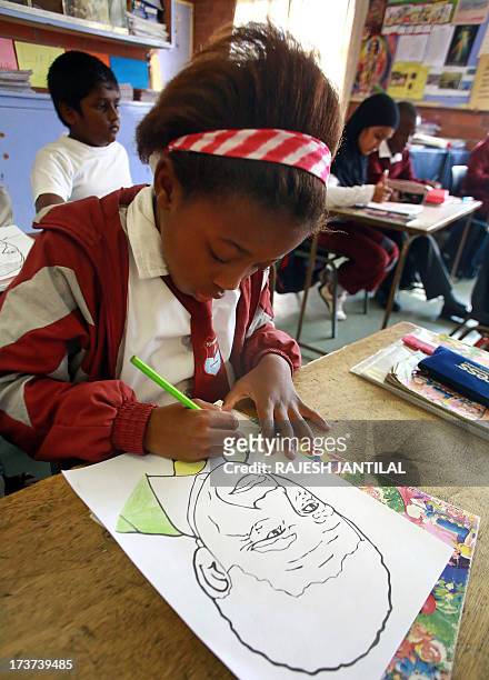 Grade 3 learner from the Northlen Primary School in Phoenix, north of Durban, colours on a chart of former South African President Nelson Mandela in...