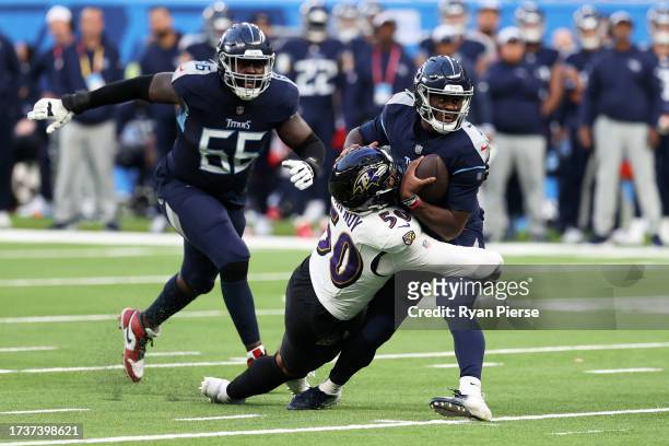 Malik Willis of the Tennessee Titans is sacked by Kyle Van Noy of the Baltimore Ravens in the fourth quarter during the 2023 NFL London Games match...