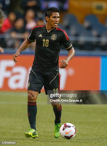 Juan Carlos Valenzuela of Mexico dribbles against Canada at CenturyLink Field on July 11, 2013 in Seattle, Washington.