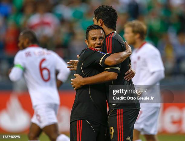 Raul Jimenez of Mexico gets a hug from Luis Montes after scoring a goal against Canada at CenturyLink Field on July 11, 2013 in Seattle, Washington.