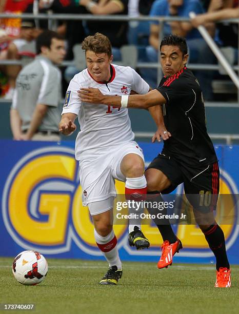 Samuel Piette of Canada dribbles against Marco Fabian of Mexico at CenturyLink Field on July 11, 2013 in Seattle, Washington.