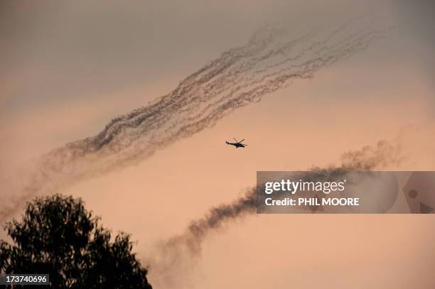 Congolese army helicopter flies amidst smoke from rockets fired at M23 positions north of Goma in the east of the Democratic Republic of the Congo on...