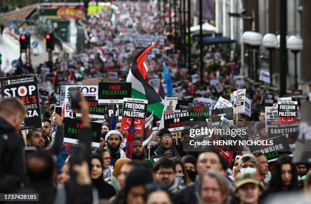 People take part in a 'March For Palestine', in London on October 21 to "demand an end to the war on Gaza". The UK has pledged its support for Israel...