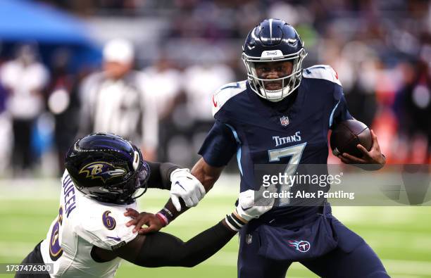 Malik Willis of The Titans is tackled by Patrick Queen of The Ravens during the NFL match between Baltimore Ravens and Tennessee Titans at Tottenham...