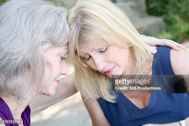 two female friends praying with one another - old lady crying out for help stock pictures, royalty-free photos & images