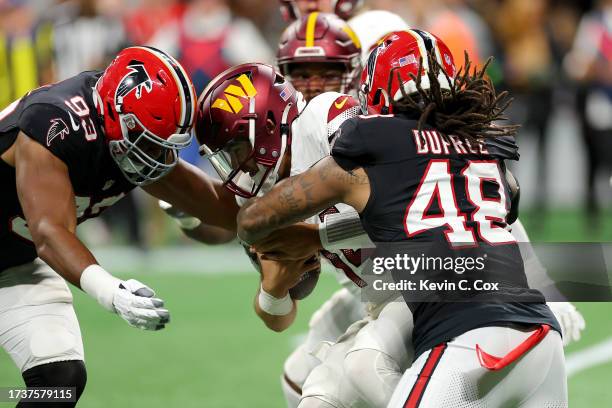 Calais Campbell of the Atlanta Falcons and Bud Dupree of the Atlanta Falcons sack Sam Howell of the Washington Commanders during the second quarter...