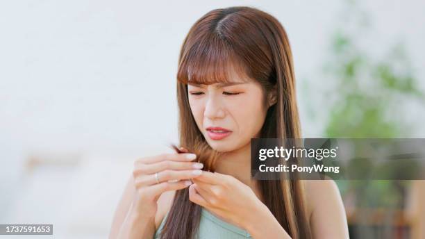 une femme asiatique a les cheveux abîmés - dry hair photos et images de collection