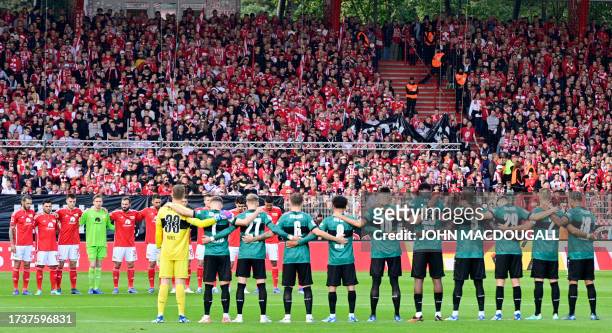 Players of Union Berlin and VfB Stuttgart observe a minute of silence for the victims of the Israeli-Palestinian conflict before the start of the...