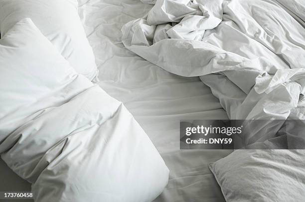 disheveled sheets and pillows of an unmade bed - sheets stock pictures, royalty-free photos & images