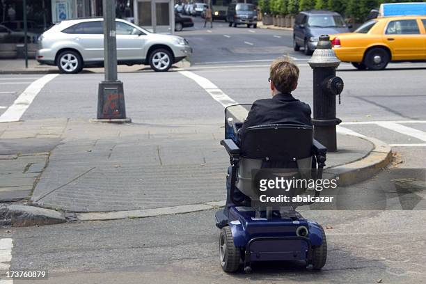 cruzar la calle para personas con discapacidades - mobility scooter fotografías e imágenes de stock