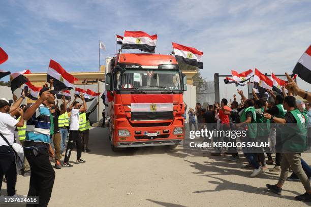 Egyptian aid workers celebrate as an aid truck crosses back into Egypt through the Rafah border crossing with the Gaza Strip on October 21, 2023. The...