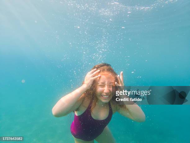 portrait of a crazy teenage girl shouting underwater - underwater stock pictures, royalty-free photos & images