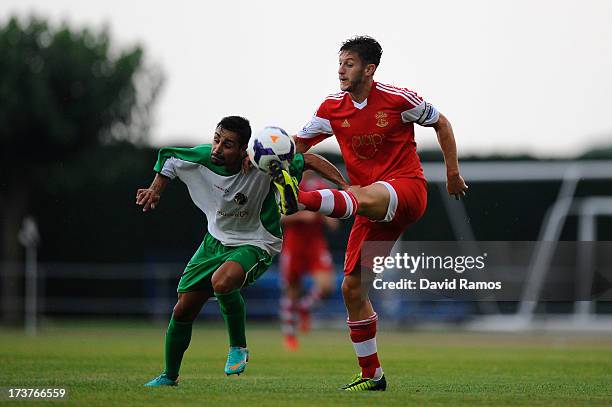 Adam Lallana of Southampton duels for the ball with Marc Garcia of UE Llagostera during a friendly match between Southampton FC and UE Llagostera at...