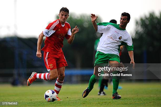 Jay Rodriguez of Southampton duels for the ball with Marc Garcia of UE Llagostera during a friendly match between Southampton FC and UE Llagostera at...