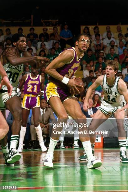 Kareem Abdul-Jabbar of the Los Angeles Lakers drives to the basket as Danny Ainge and Robert Parish of the Boston Celtics defend during the 1984 NBA...