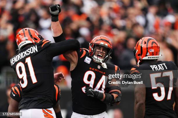 Trey Hendrickson and Sam Hubbard of the Cincinnati Bengals celebrate with teammates after a sack during the fourth quarter against the Seattle...