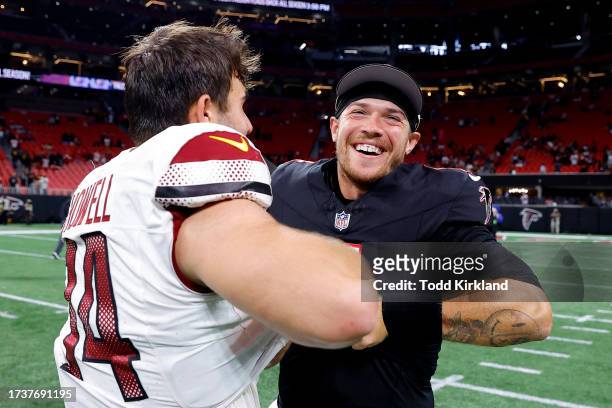 Sam Howell of the Washington Commanders and Taylor Heinicke of the Atlanta Falcons hug after Washington's 24-16 win at Mercedes-Benz Stadium on...