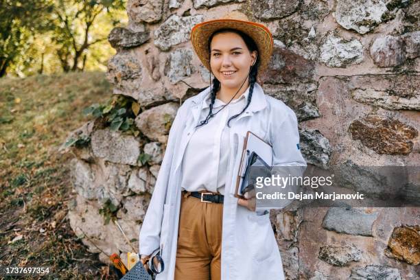 portrait of young archeologist working on the field - archeoloog stockfoto's en -beelden
