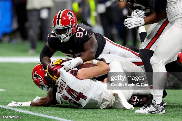 Grady Jarrett of the Atlanta Falcons sacks Sam Howell of the Washington Commanders during the fourth quarter at Mercedes-Benz Stadium on October 15,...