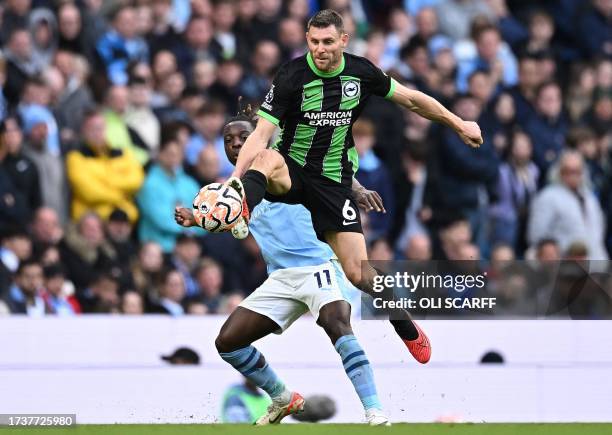 Manchester City's Belgian midfielder Jeremy Doku vies with Brighton's English midfielder James Milner during the English Premier League football...