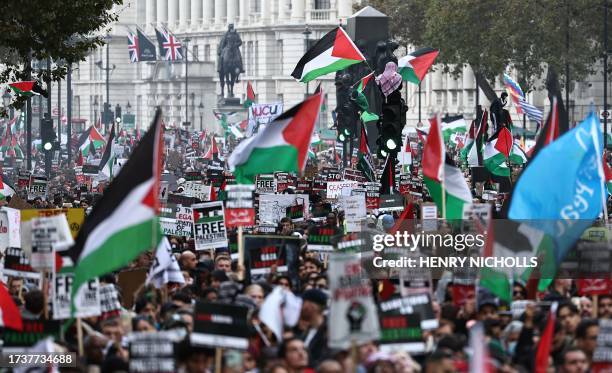 People take part in a 'March For Palestine', in London on October 21 to "demand an end to the war on Gaza". The UK has pledged its support for Israel...