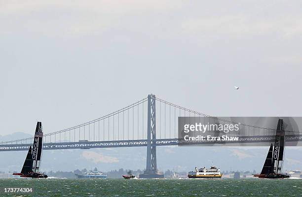 Oracle Team USA sail both of their AC72's past the San Francisco-Oakland Bay Bridge while training for the America's Cup sailing event on July 17,...