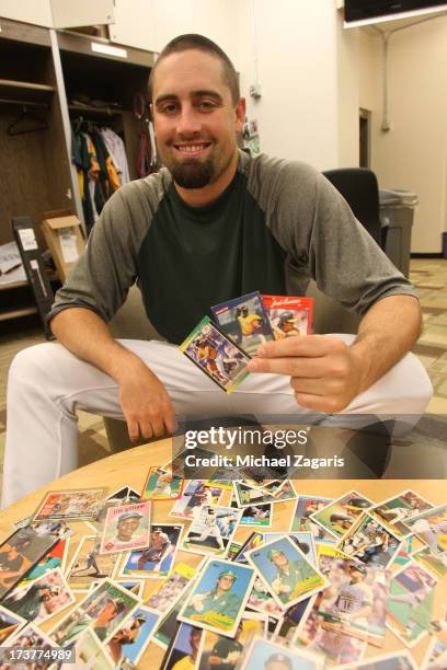 Pat Neshek of the Oakland Athletics shows off part of his baseball card collection in the clubhouse prior to the game against the Chicago Cubs at...