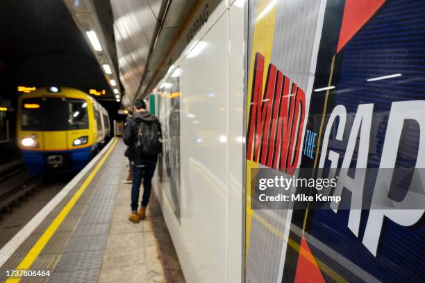 Mind the gap poster as a train approaches London Overground platform inside Wapping station on 18th October 2023 in London, United Kingdom. The...