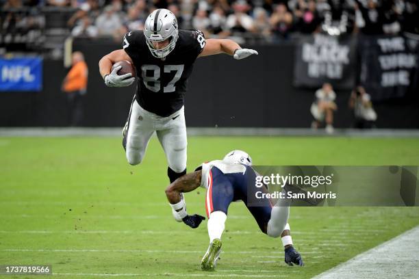 Michael Mayer of the Las Vegas Raiders attempts to hurdle Jalen Mills of the New England Patriots during the first quarter at Allegiant Stadium on...