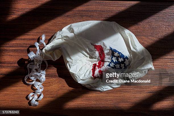 a deflated balloon with the us flag on it - deflated stock-fotos und bilder