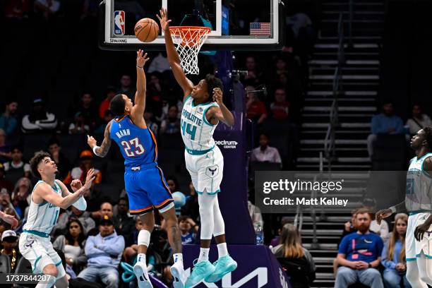 Frank Ntilikina of the Charlotte Hornets blocks a shot from Tre Mann of the Oklahoma City Thunder during the first quarter of the game at Spectrum...