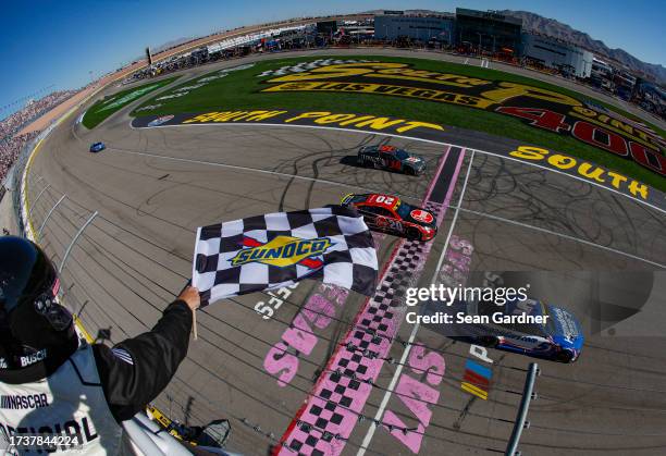 Kyle Larson, driver of the HendrickCars.com Chevrolet, takes the checkered flag over Christopher Bell, driver of the Rheem/Smurfit Kappa Toyota, to...