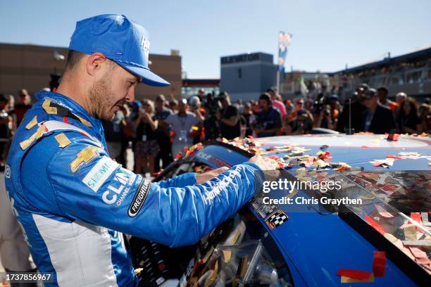 Kyle Larson, driver of the HendrickCars.com Chevrolet, places the winner sticker on his car in victory lane after winning the NASCAR Cup Series South...