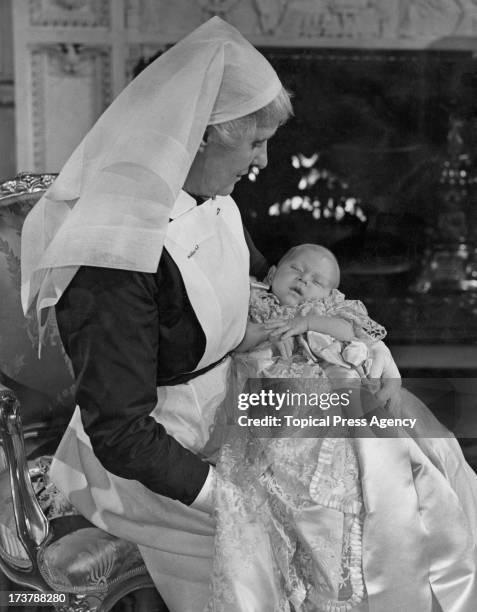 The infant Prince Charles in the arms of his nurse, Sister Helen Rowe, after his christening at Buckingham Palace, London, 18th December 1948.