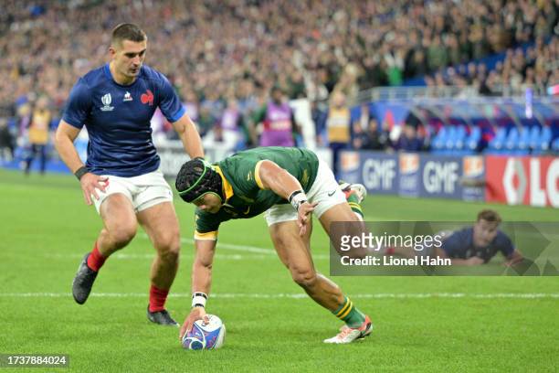 Cheslin Kolbe of South Africa beats Damian Penaud of France to score his team third try during the Rugby World Cup France 2023 Quarter Final match...