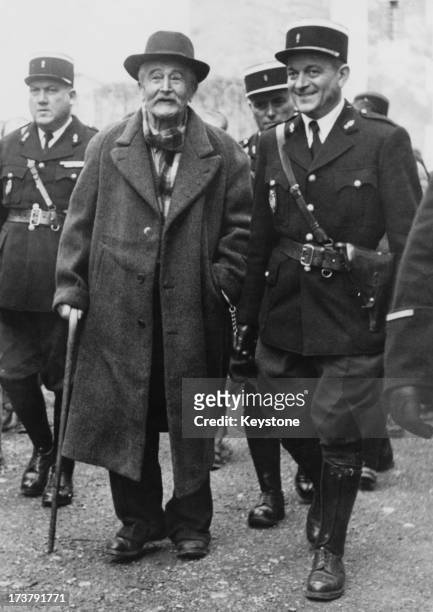 French farmer Gaston Dominici is escorted by police officers during his trial for the murders of British biochemist Sir Jack Drummond , his wife Anne...