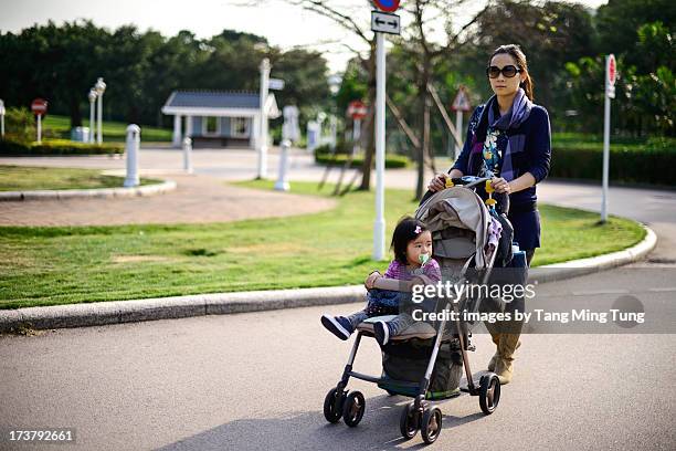 young mom pushing baby in stroller - baby accessories the dummy stock pictures, royalty-free photos & images