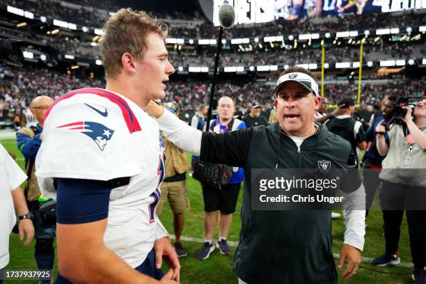 Mac Jones of the New England Patriots talks to head coach Josh McDaniels of the Las Vegas Raiders after Las Vegas' 21-17 win at Allegiant Stadium on...