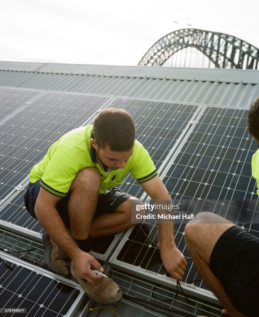 Men installing solar panels on roof