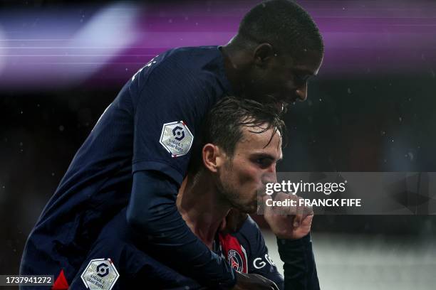 Paris Saint-Germain's Spanish midfielder Fabian Ruiz celebrates with Paris Saint-Germain's French forward Ousmane Dembele scoring his team's third...