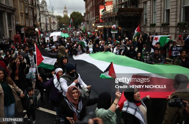 People take part in a 'March For Palestine', in London on October 21 to "demand an end to the war on Gaza". The UK has pledged its support for Israel...