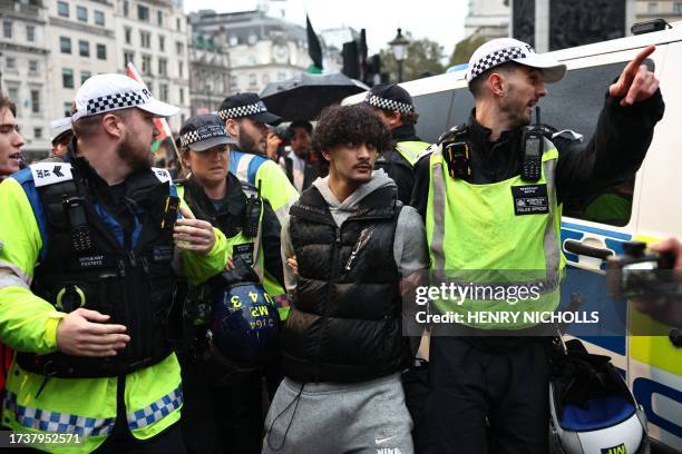 Police officers detain a protestor during a 'March For Palestine', in London on October 21 during a demonstration to "demand an end to the war on...