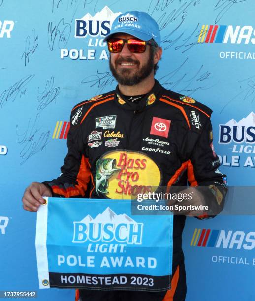 Martin Truex, Jr receives the Busch Light Pole Award after qualifying on the pole for the NASCAR Cup Series Playoff Dixie Vodka 400 on October 21 at...