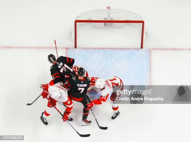 Brady Tkachuk and Ridly Greig of the Ottawa Senators battle for position against Ben Chiarot and Dylan Larkin of the Detroit Red Wings in front of...